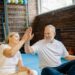 Energetic senior couple enjoying yoga, sharing a joyful high-five at the gym., tags: functional strength - pexel